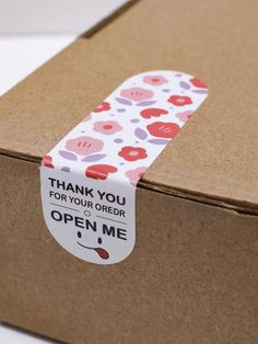 an open box with a thank you for your order sticker taped to it's side