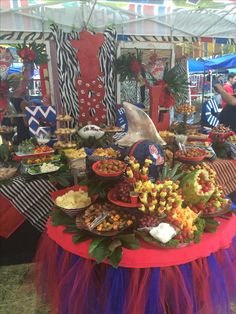 a table topped with lots of food under a tent