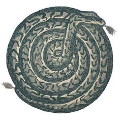 a round rug with green and white designs on the bottom, in front of a white background