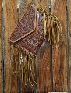 Introducing our latest Artisan Tooled Leather Fringe Bag, a stunning handmade leather clutch for women. We’ve used premium buffalo leather and added a suede leather tassel on the side to give it that rich, luxurious look. Plus, it comes with a detachable belt so you can carry it as a crossbody. Product Details: Material: Cowhide, ,Genuine LeatherDimensions: Height 22cm x Length 28cm x Width 2cm Height 8.6" x Length 11" X Width 0.7" Zipper: YKK Premium Zipper Inner Lining: Cotton (Primary Fabric) Interior: High-quality cloth lining for a polished lookOne zipper pocket for money and cardsOne open pocket for your small wallet or other essentialsDiscover the exquisite craftsmanship of our Handmade Buffalo Leather Sling Bag, designed for women who want style and functionality. Each bag is hand- Elegant Leather Clutch With Hand Tooled Details, Leather Fringe Clutch Bag, Hand Tooled Travel Clutch, Hand Tooled Leather Pouch Wallet, Hand Tooled Leather Clutch Wallet, Hand-tooled Leather Clutch Wallet, Hand Tooled Leather Clutch, Elegant Hand Tooled Leather Wallets, Handmade Brown Leather Clutch