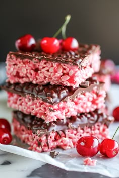 chocolate cherry rice krispy treats stacked on top of each other with cherries around them