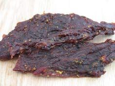 two pieces of beef sitting on top of a wooden cutting board