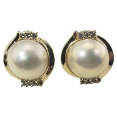 Vintage 14 Karat Yellow Gold Mabe Pearl and Diamond Clip On Earrings- These lovely earrings each feature one Mabe Pearl (14 mm) and six round brilliant cut diamonds set in classic 14K yellow gold. Omega back closures. Approximate total diamond weight: .36 ct. Diamond clarity: SI1 Diamond color: G-H Size: 20 mm x 18 mm Weight: 8.0 dwt. / 12.5 gr. Stamped: 14K Very good condition, professionally polished. Will come packaged in a gift box or pouch (when possible) and will be shipped U.S. Priority M Mabe Pearl, Pearl And Diamond Earrings, Pearl Diamond, Lovely Earrings, Diamond Color, Cream And Gold, Round Brilliant Cut Diamond, Diamond Clarity, Estate Jewelry