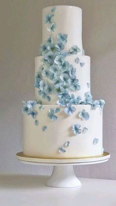 a three tiered cake with blue flowers on it