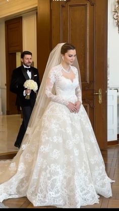 a woman in a wedding dress standing next to a man