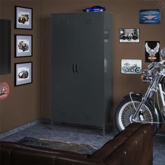 a motorcycle is parked next to a locker in a room with pictures on the wall