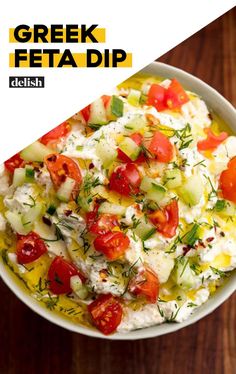 greek feta dip with tomatoes, cucumbers and herbs in a white bowl