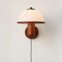 a lamp that is on the wall with a cord attached to it and plugged in