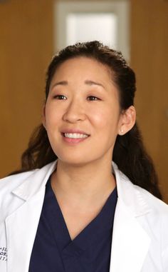 a woman wearing a white lab coat smiles at the camera