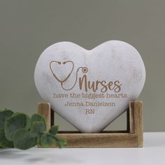 a white heart shaped plaque with the words nurses have the biggest hearts