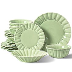 green dishes and cups are stacked on top of each other