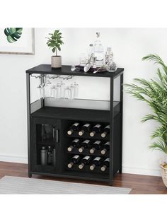 a black and white bar cart with wine glasses on the top, next to a potted plant