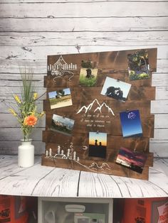 a wooden board with pictures and photos on it next to a vase filled with flowers