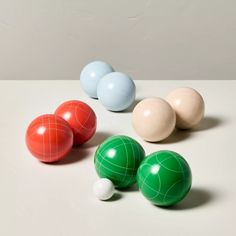 three balls and four spheres on a white surface with one ball facing the other direction