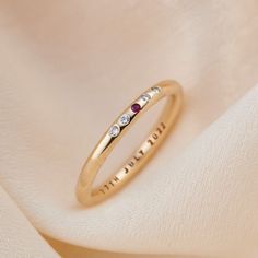 a gold ring with three stones on it and the word love written in cursive writing