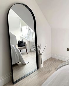 a bedroom with a large mirror on the wall