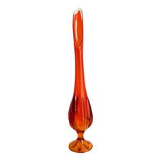 an orange glass vase sitting on top of a table