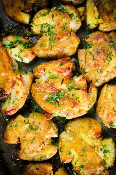 chicken and potatoes in a pan with parsley sprinkled on the top, ready to be cooked