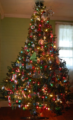 a brightly lit christmas tree in the corner of a room