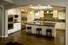 an open kitchen with white cabinets and black counter tops