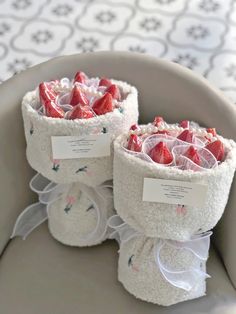 two baskets filled with strawberries sitting on top of a table