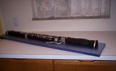 an old flute is sitting on top of a blue mat and it's resting on a counter