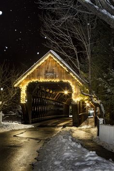 a house covered in christmas lights with snow on the ground