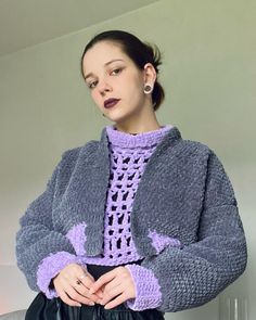 a woman wearing a purple sweater and black skirt