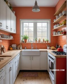 a kitchen with orange walls and white cabinets