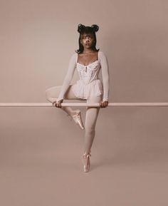 a ballerina is sitting on the bar with her legs stretched out in front of her