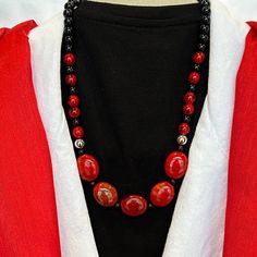 Elevate Your Holiday Look With Our Holiday Radiance Red And Black Necklace With Drop Earrings Set. This Exquisite Ensemble Features A 20.5-Inch Necklace Adorned With Oval Glass Stones, Each With Mesmerizing Black Movement Coursing Through Them, Adding A Touch Of Dynamic Elegance. Elegant Red Beaded Necklace With Black Beads, Elegant Red And Black Beaded Necklaces, Elegant Red And Black Beaded Necklace, Red Necklace With Black Beads For Party, Formal Red Beaded Jewelry, Adjustable Red Jewelry With Black Beads, Formal Red Beaded Round Necklaces, Red And Black Necklace, Black Movement