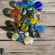 a bunch of glass marbles sitting on top of a wooden table