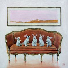 three rabbits sitting on a couch in front of a painting