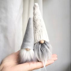 a hand holding two gnome hats on top of each other