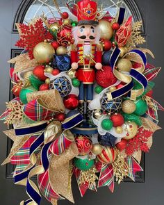 a christmas wreath with a nutcracker and decorations on it's front door