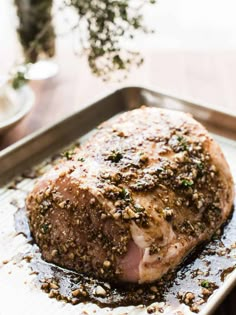 a piece of meat sitting on top of a pan covered in spices and seasoning