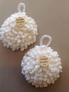 two white crocheted ornaments with names on them