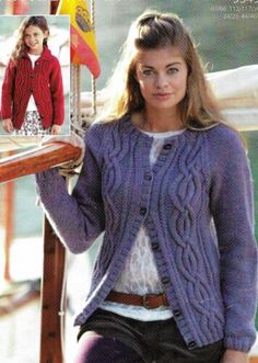 a woman in purple sweater and leggings standing next to a boat with an image of a woman on it