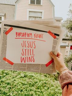 a person holding up a newspaper with the words breaking news jesus still wins written on it