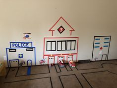 a room with toys on the floor and police station painted on the wall