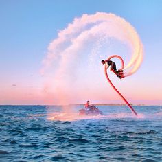 a person on a surfboard being pulled by a water hose