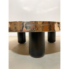 two black vases sitting on top of each other near a gold plated table