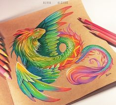 a drawing of a colorful bird sitting on top of a piece of paper next to colored pencils