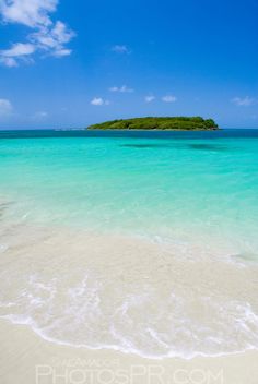 an island in the distance with blue water and white sand