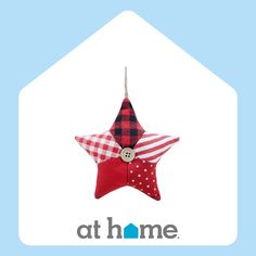 a red and white star ornament hanging from a blue background with the words at home written below it