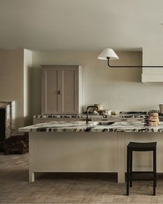 a kitchen with an island and stools next to the counter top in front of it