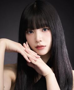 a woman with long black hair posing for the camera