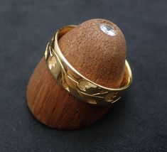 a wooden object with two gold rings on it's sides and a diamond in the middle