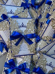 blue and gold wedding cards with royal crowns on them, tied in satin ribbon bows