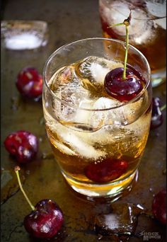 two glasses filled with ice and cherries